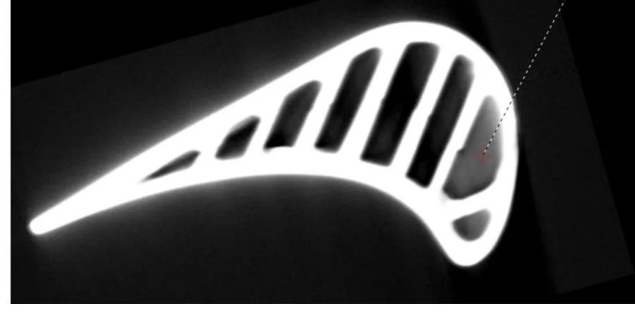 CT slice through a turbine blade showing the internal cooling channels and a measured feature